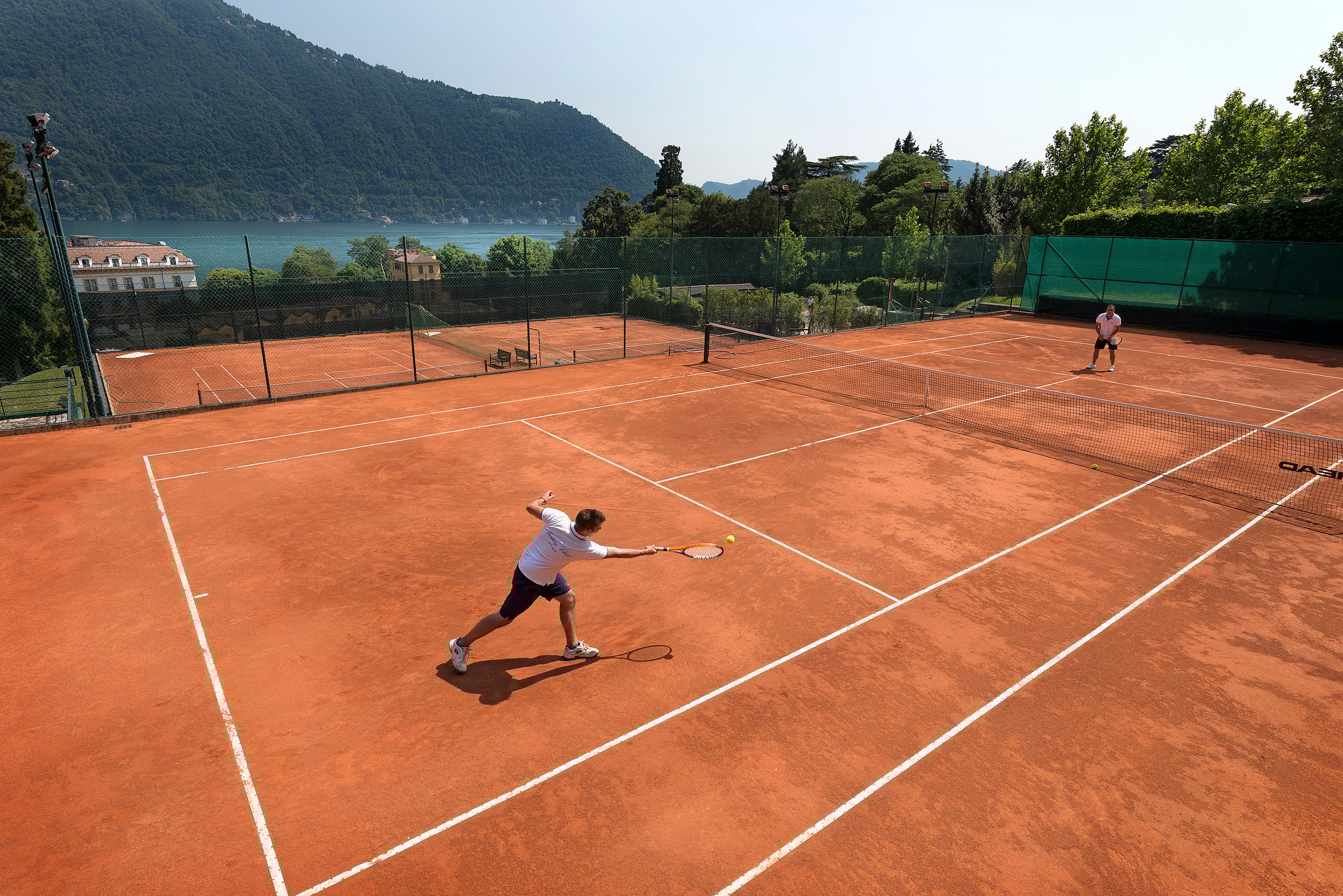 Tennis courts with lake view with 2 tennis players