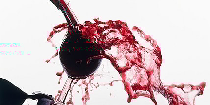 Red wine spilling overfilled glass GettyImages-131985876.jpg