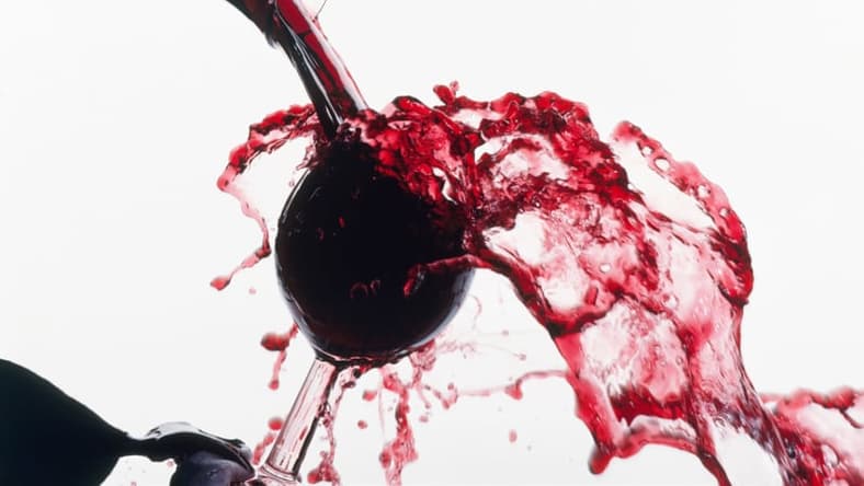 Red wine spilling overfilled glass GettyImages-131985876.jpg