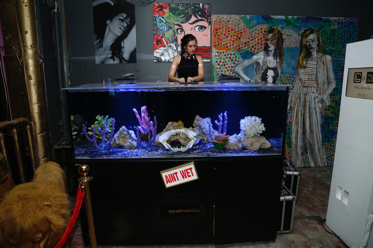 Sasha Grey doing a surprise DJ set on GLDC's custom built saltwater fish tank DJ booth during Fashion Week at Saks.