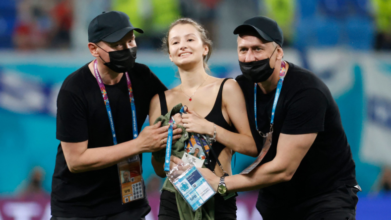Stadium security stop a pitch invader during the UEFA EURO 2020 Group B football match between Finland and Belgium at Saint Petersburg Stadium in Saint Petersburg